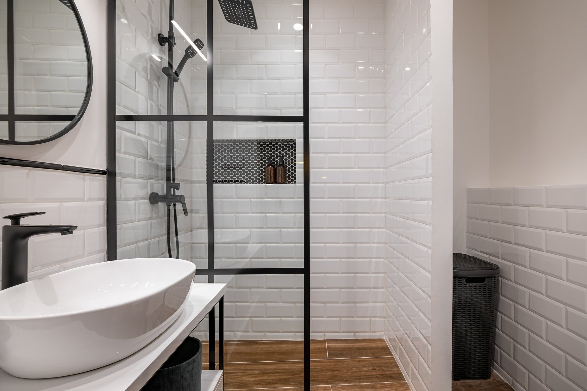 Modern bathroom featuring glass shower enclosure, white subway tile walls