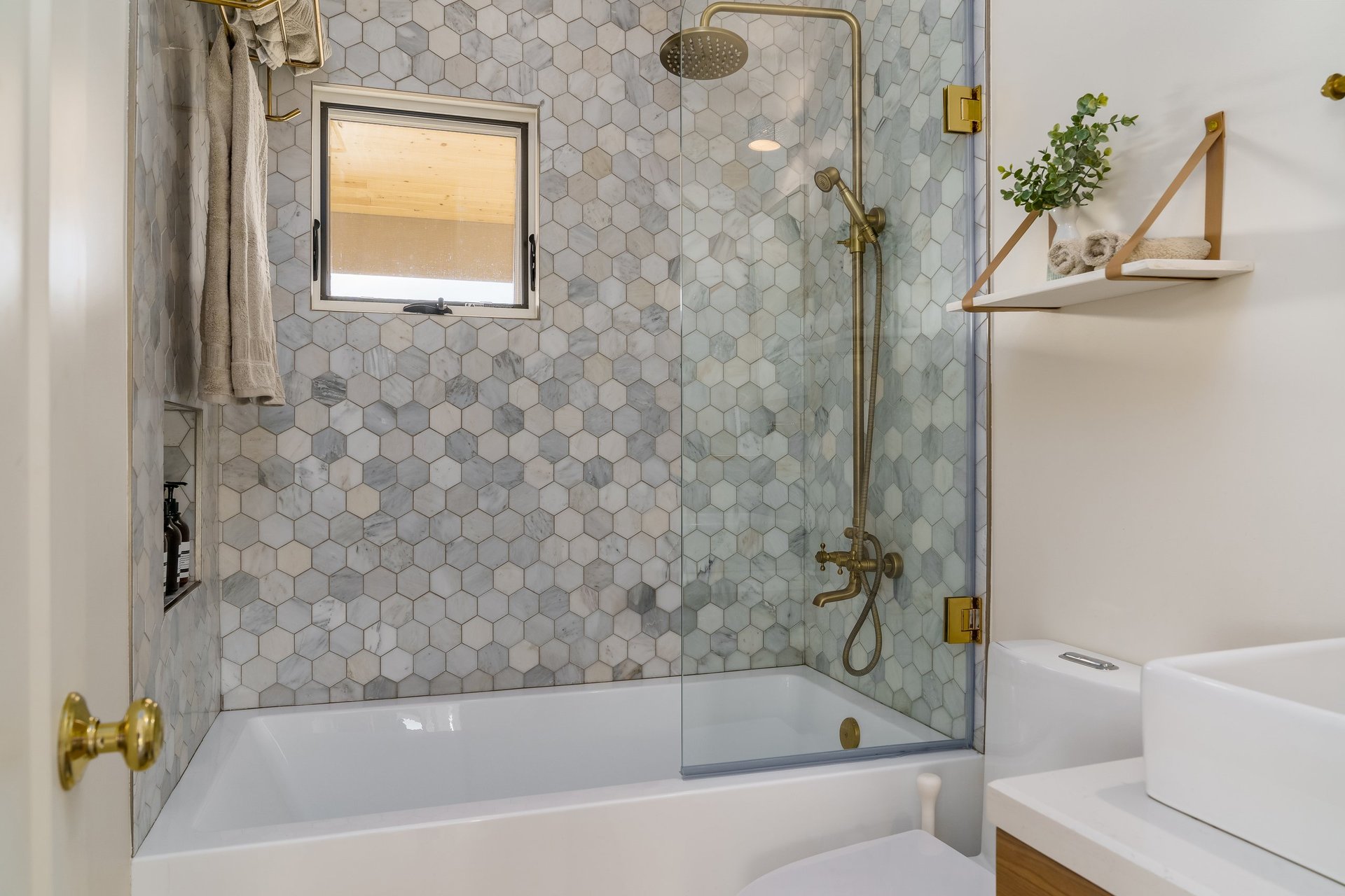 Modern bathroom with bathtub and gold brass fixtures
