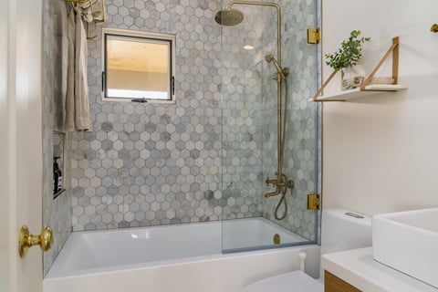 Modern bathroom in white with shower tub and gold brass fixtures