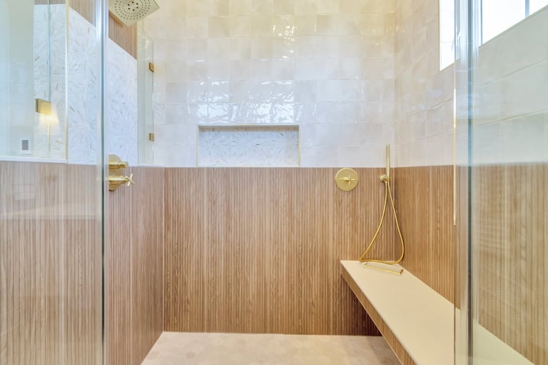 A large walk-in shower with tiled walls and bench seat