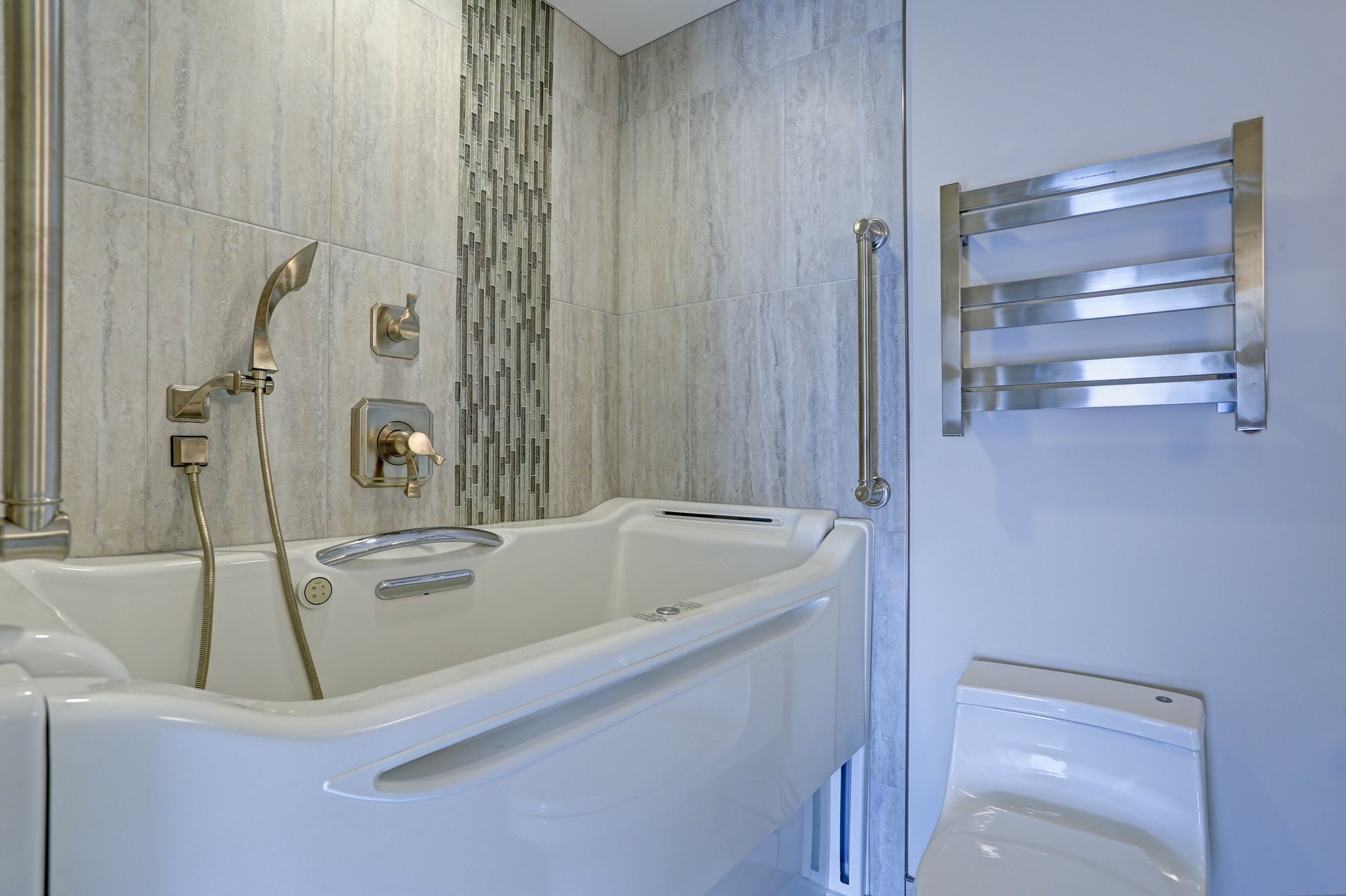 Luxury walk-in bathtub flanked by subway tiled interior