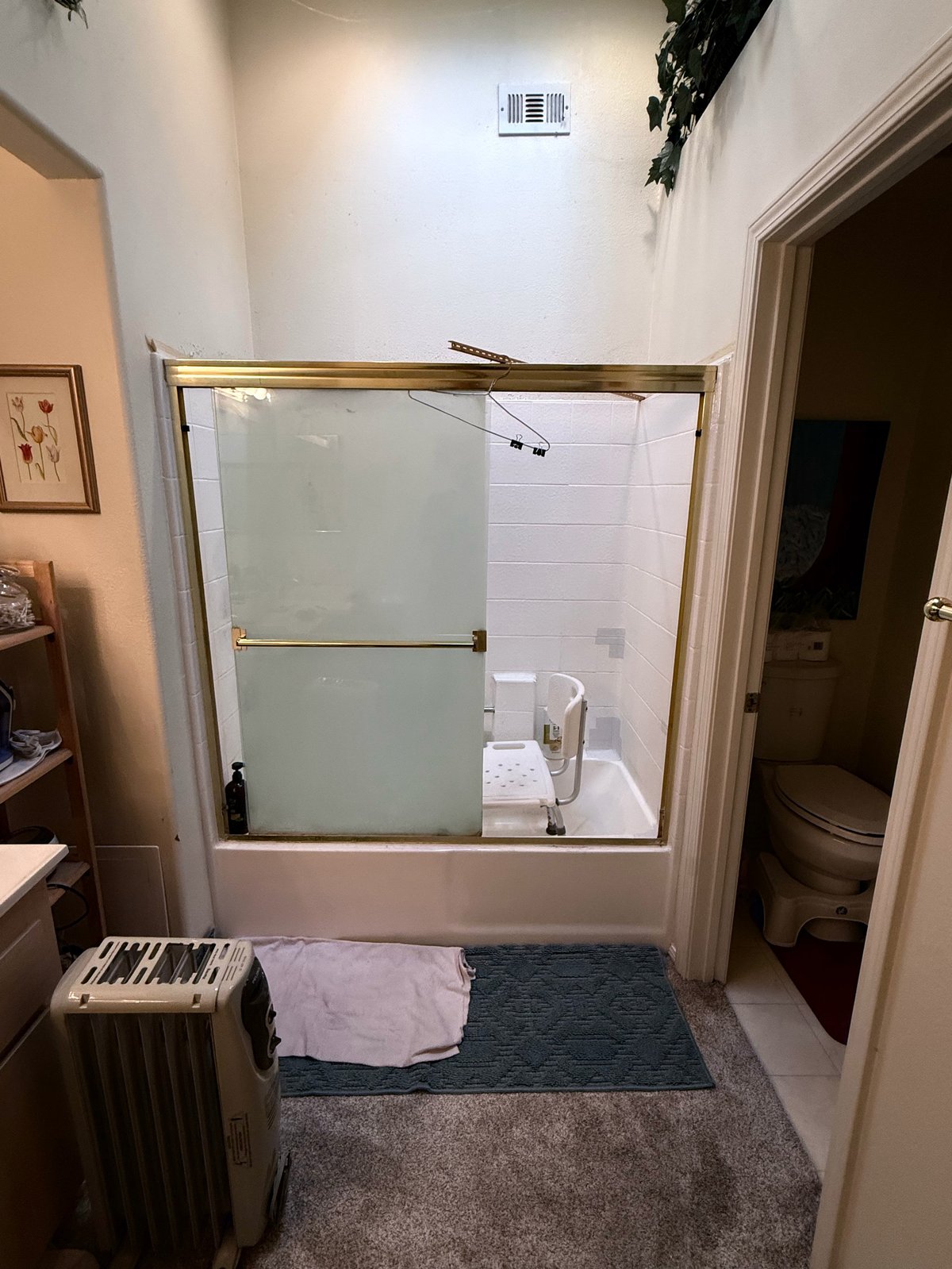 Modern bathroom with frameless glass shower enclosure, rainfall showerhead, and white tile interior