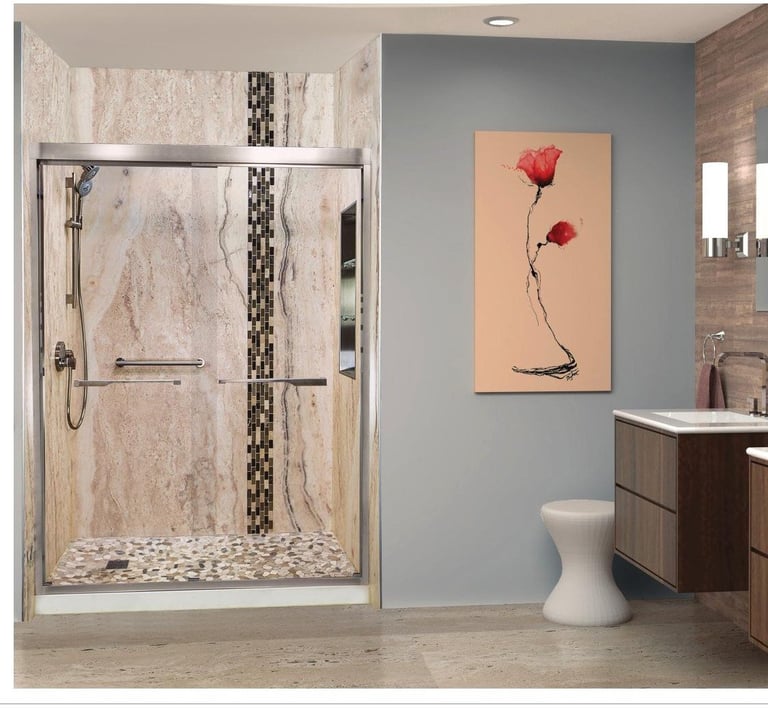 Modern bathroom with glass shower enclosure, blue-gray walls, white pedestal sink, and floral artwork
